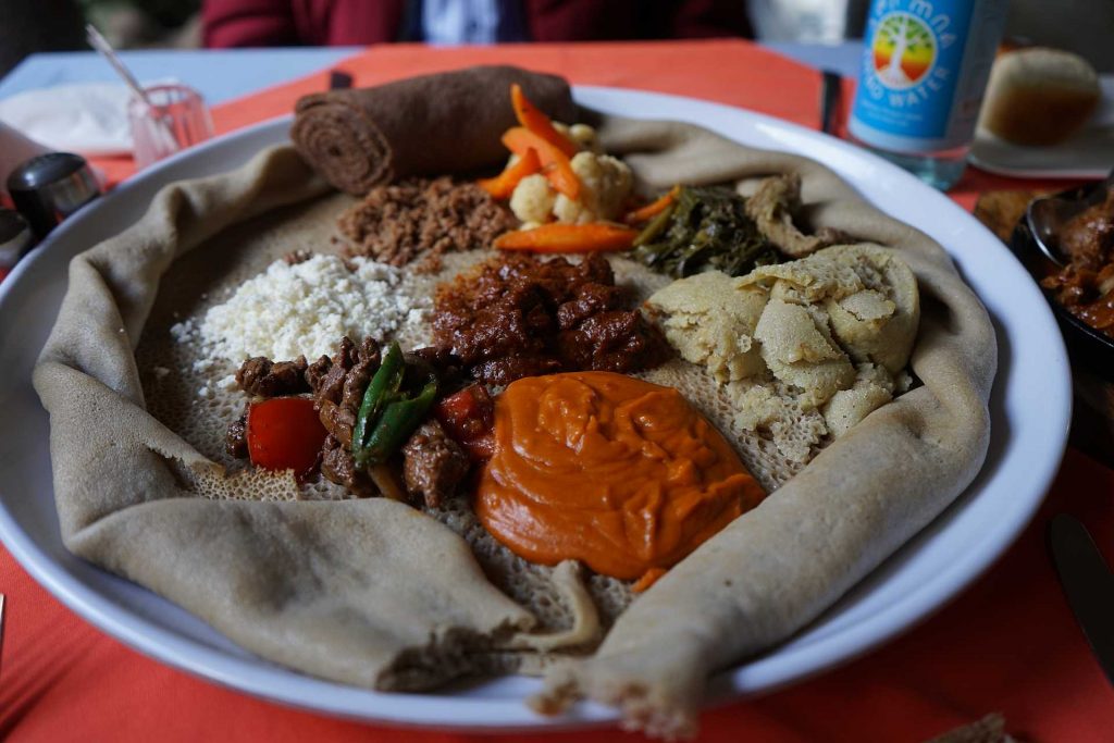 Ein Mix äthiopischer Spezialitäten angerichtet auf einer Injera - Photo: LCTours